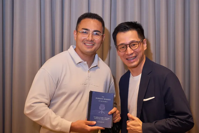 Yan Sen Lu with a guest holding the book